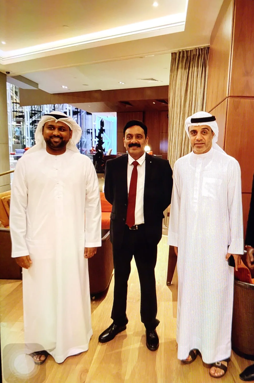 Mohammed Shakeel Hashmi with two partners in a hotel lobby in Dubai