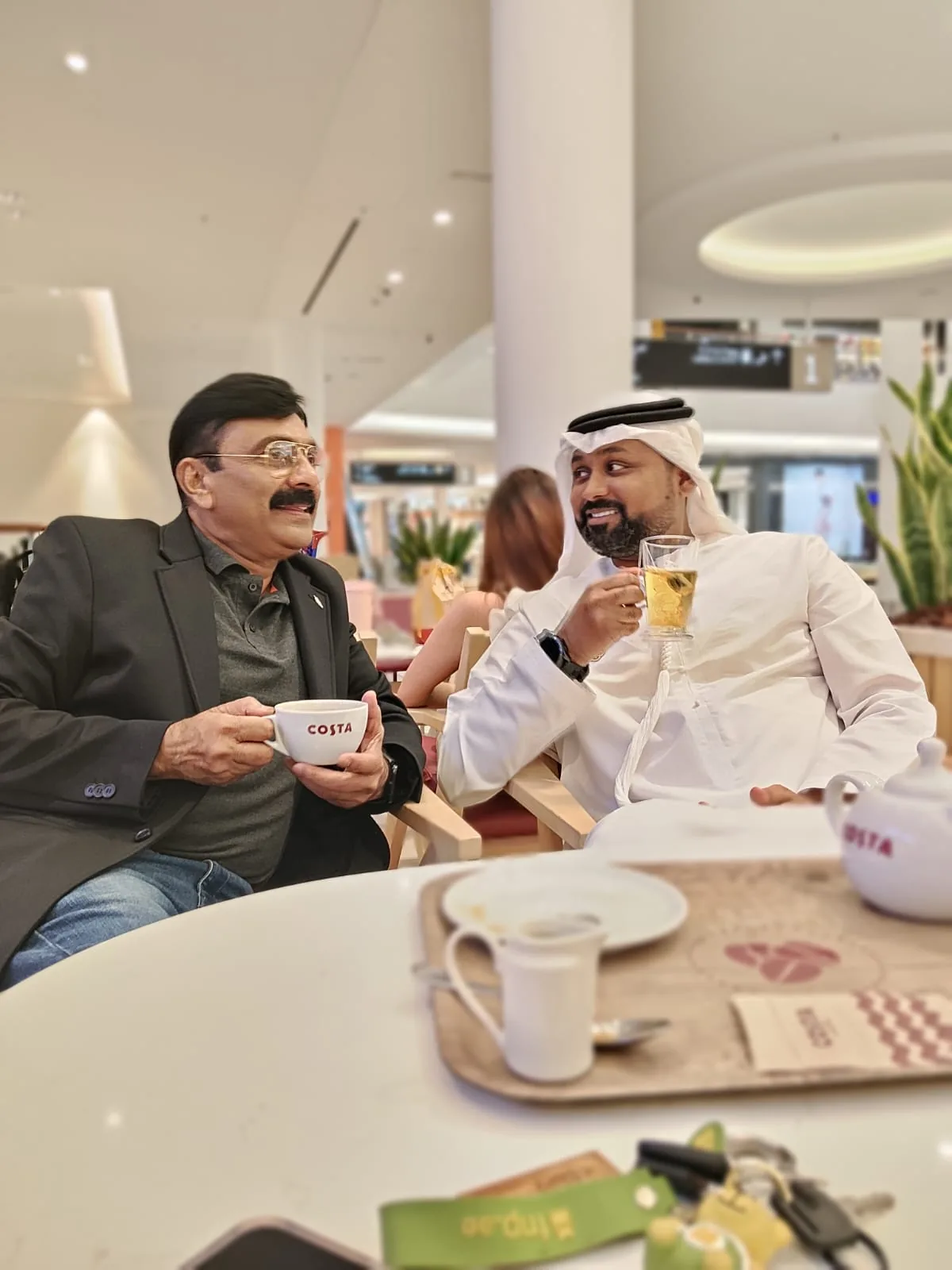 Mohammed Shakeel Hashmi in conversation with a partner over coffee in Dubai