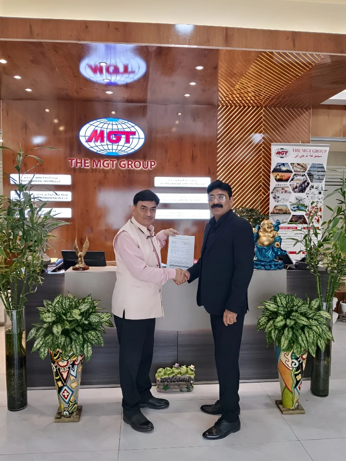 Mohammed Shakeel Hashmi shaking hands over a signed agreement at a partner company in Dubai