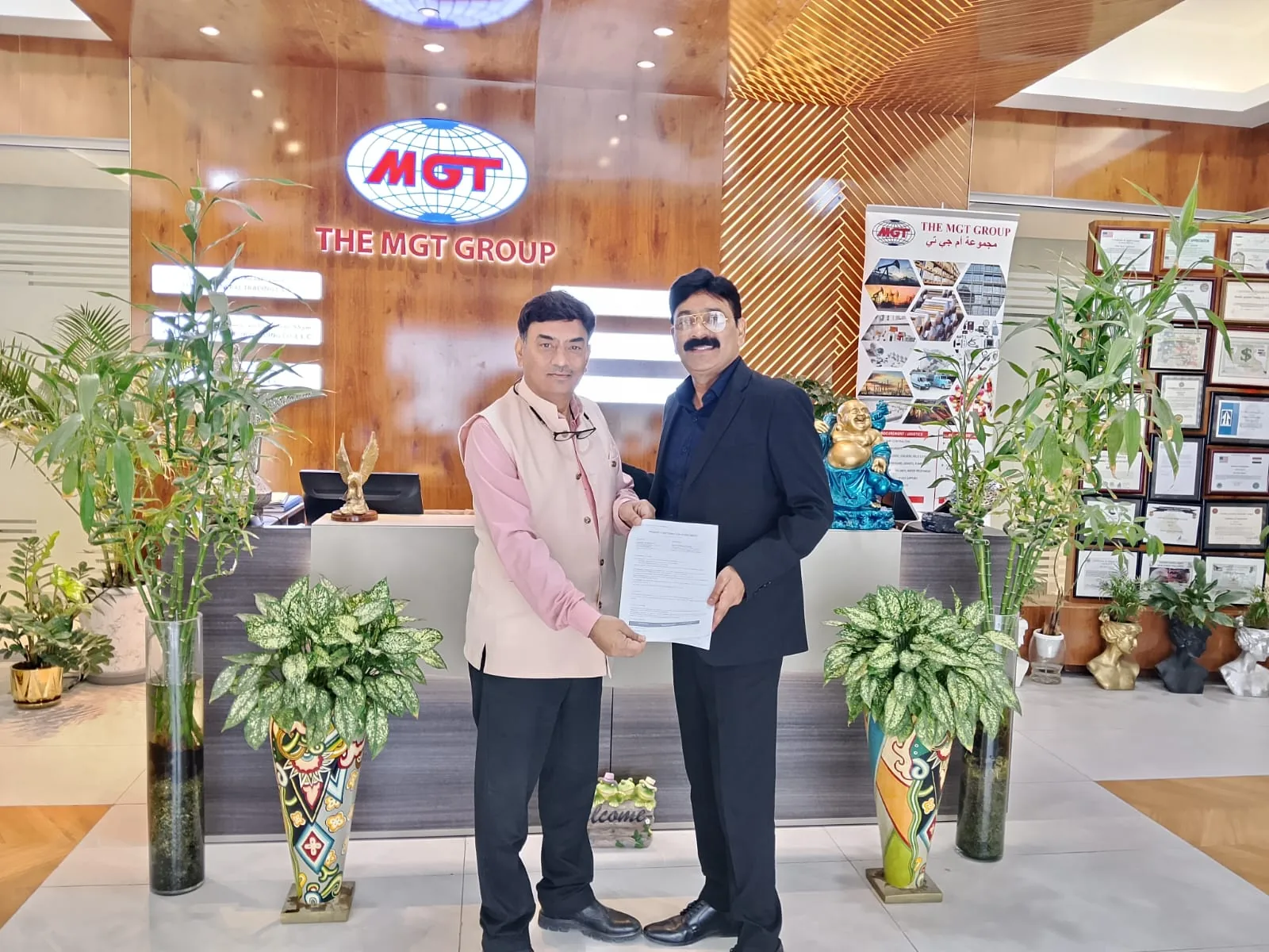 Mohammed Shakeel Hashmi holding a signed agreement with a partner at their Dubai offices