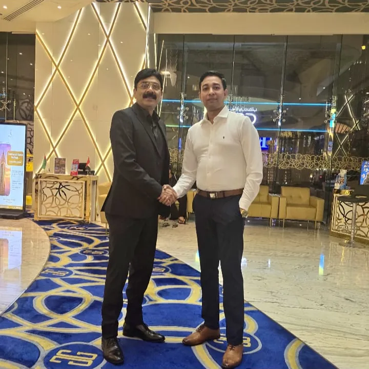 Two people shaking hands in a hotel lobby
